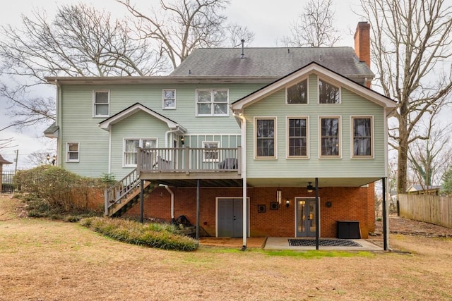 back of house with a wooden deck, a patio area, and a lawn