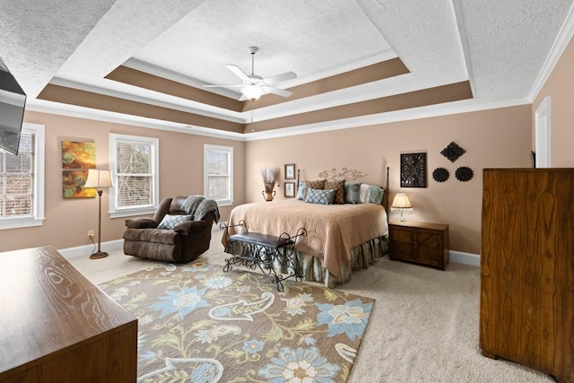 bedroom featuring ceiling fan, ornamental molding, a textured ceiling, light carpet, and a raised ceiling