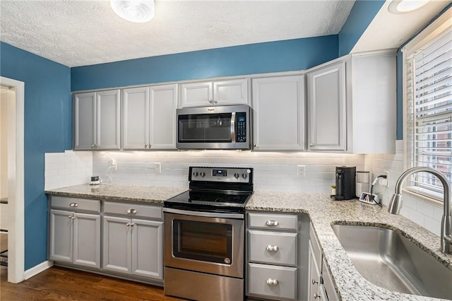 6700 Roswell Rd NE Unit 25A, Sandy Springs, GA 30328 - kitchen with stainless steel appliances, a sink, backsplash, dark wood-type flooring, and a textured ceiling