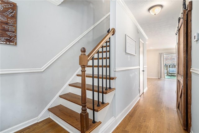 6700 Roswell Rd NE Unit 25A, Sandy Springs, GA 30328 - staircase with wood finished floors, baseboards, crown molding, and a barn door