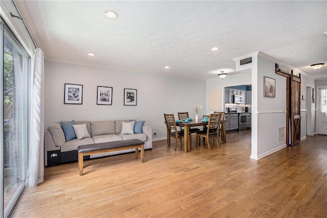 6700 Roswell Rd NE Unit 25A, Sandy Springs, GA 30328 - living room with a barn door, plenty of natural light, recessed lighting, light wood-style flooring, and baseboards