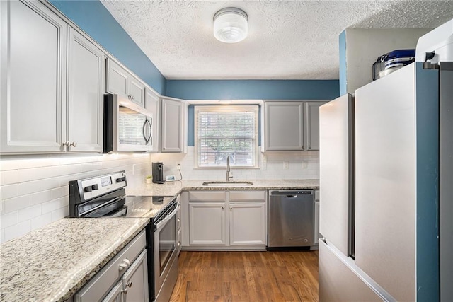 6700 Roswell Rd NE Unit 25A, Sandy Springs, GA 30328 - kitchen featuring stainless steel appliances, a sink, decorative backsplash, dark wood-style flooring, and a textured ceiling