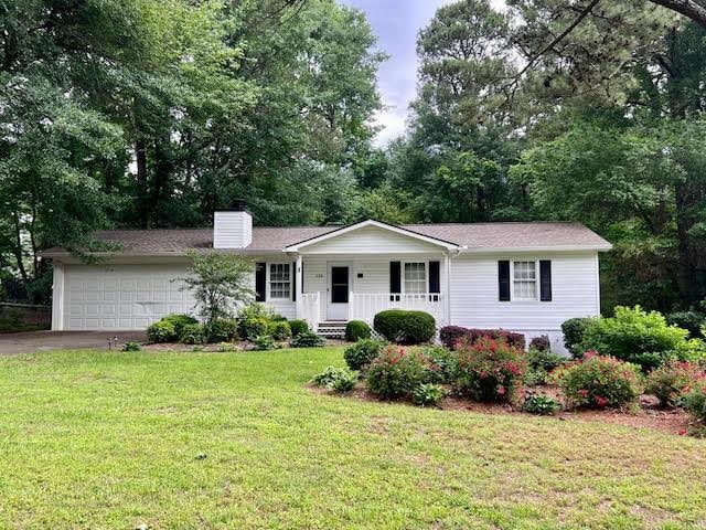 135 Sequoyah Dr, Alpharetta, GA 30004 - single story home with covered porch, an attached garage, driveway, a chimney, and a front yard
