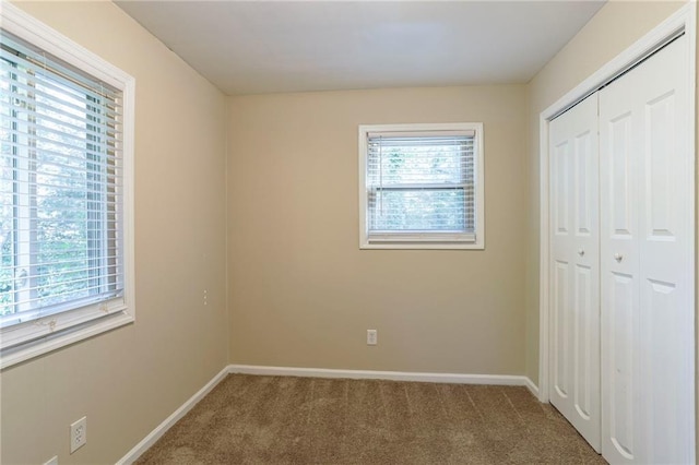 unfurnished bedroom featuring carpet flooring and a closet