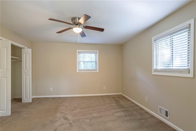 unfurnished bedroom featuring light carpet, a closet, and ceiling fan