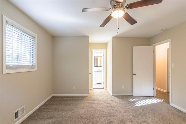 unfurnished room featuring ceiling fan and light colored carpet