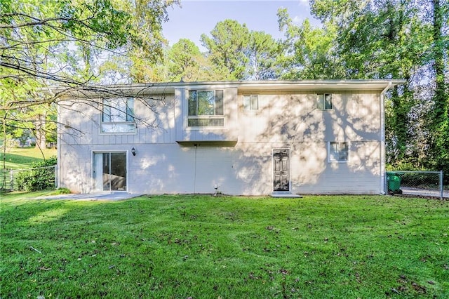 rear view of house featuring a yard