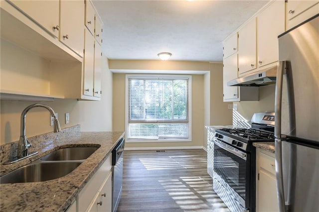 kitchen with light stone countertops, stainless steel appliances, dark hardwood / wood-style floors, and white cabinetry