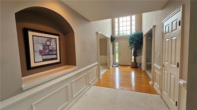2819 Heritage Oaks Cir, Dacula, GA 30019 - entrance foyer with a decorative wall, wainscoting, arched walkways, and light colored carpet