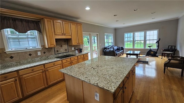 2819 Heritage Oaks Cir, Dacula, GA 30019 - kitchen with black electric stovetop, light wood-style floors, a center island, open floor plan, and decorative backsplash