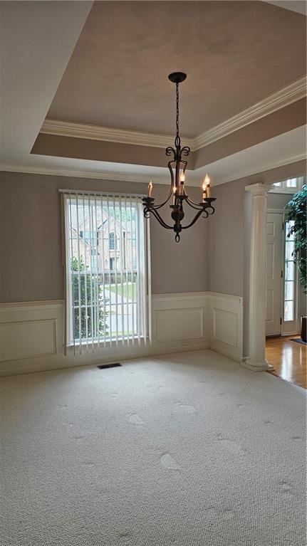 2819 Heritage Oaks Cir, Dacula, GA 30019 - unfurnished room with ornamental molding, decorative columns, a decorative wall, a chandelier, and light carpet