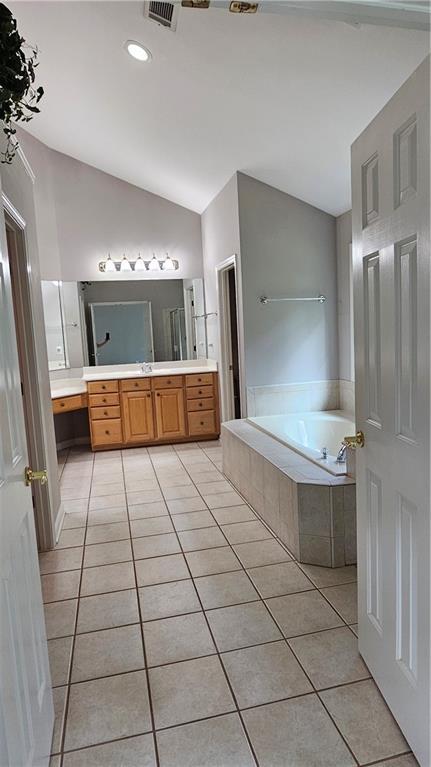 2819 Heritage Oaks Cir, Dacula, GA 30019 - full bath with lofted ceiling, tile patterned floors, a bath, and vanity