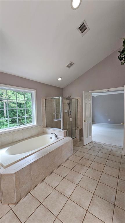 2819 Heritage Oaks Cir, Dacula, GA 30019 - full bath featuring tile patterned floors, a garden tub, a shower stall, and vaulted ceiling