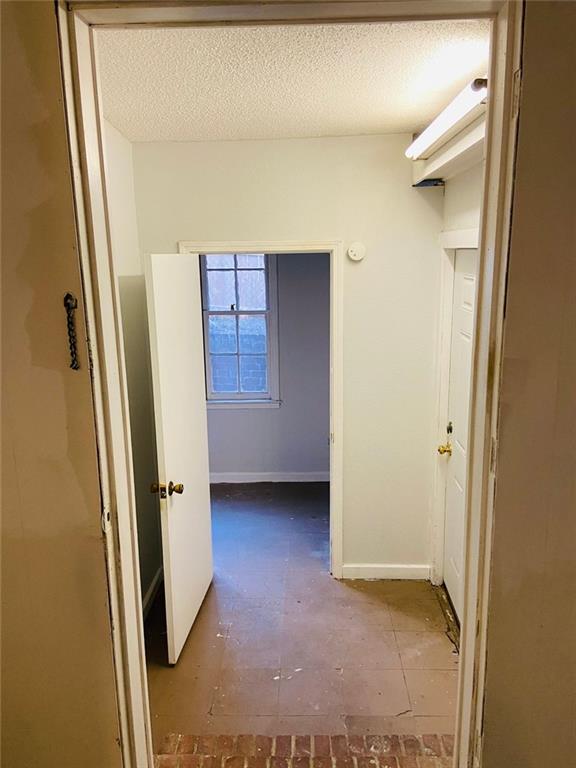 corridor featuring a textured ceiling