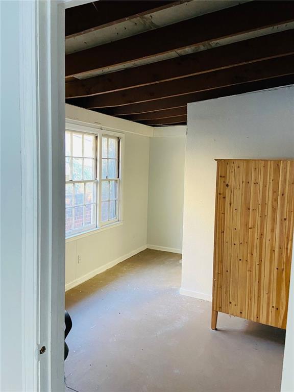 unfurnished room featuring wood walls and concrete flooring