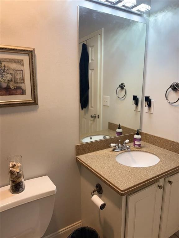 half bathroom with toilet and vanity