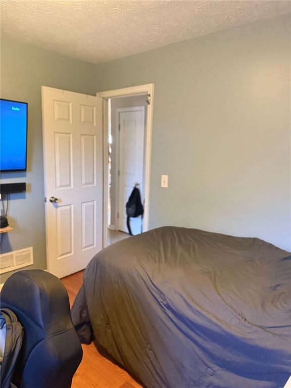 bedroom featuring a textured ceiling and wood finished floors