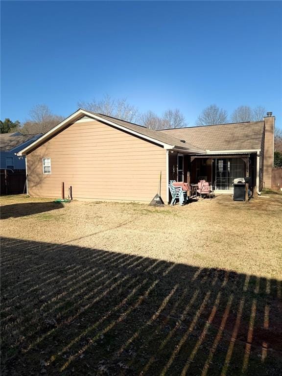 rear view of property featuring a chimney