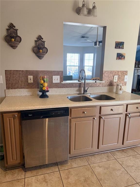 kitchen with light tile patterned flooring, a sink, light countertops, stainless steel dishwasher, and tasteful backsplash