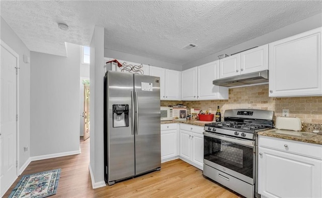 190 Crestworth Ct, Powder Springs, GA 30127 - kitchen with stainless steel appliances, under cabinet range hood, light wood finished floors, white cabinets, and a textured ceiling