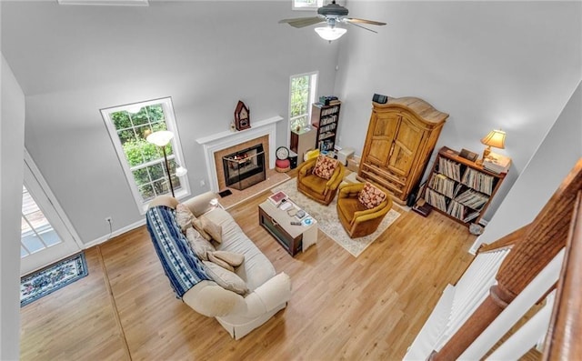 190 Crestworth Ct, Powder Springs, GA 30127 - living room featuring high vaulted ceiling, wood finished floors, a ceiling fan, a fireplace, and baseboards