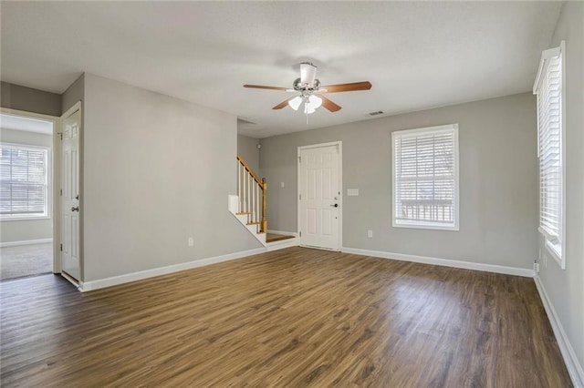 unfurnished room featuring dark hardwood / wood-style flooring, ceiling fan, and a healthy amount of sunlight