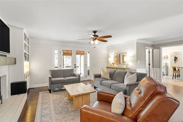 3710 Robinson Walk Ct, Marietta, GA 30068 - living room featuring ceiling fan, wood finished floors, a brick fireplace, ornamental molding, and a wainscoted wall