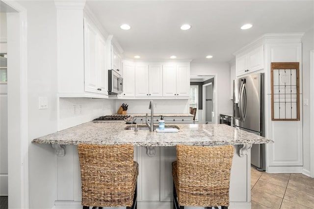 3710 Robinson Walk Ct, Marietta, GA 30068 - kitchen with appliances with stainless steel finishes, a sink, a peninsula, a breakfast bar, and white cabinets