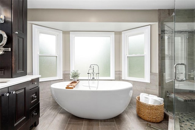 3710 Robinson Walk Ct, Marietta, GA 30068 - bathroom featuring tile walls, a freestanding tub, a wainscoted wall, a stall shower, and vanity