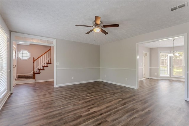 1797 Emerson Lake Cir, Snellville, GA 30078 - spare room with a textured ceiling, dark wood-style flooring, a ceiling fan, stairway, and a chandelier