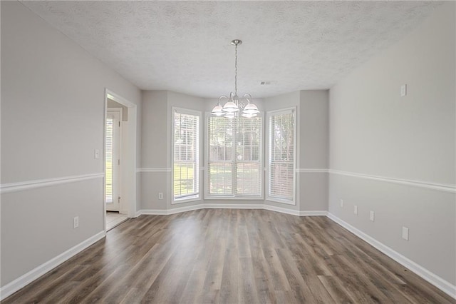 1797 Emerson Lake Cir, Snellville, GA 30078 - unfurnished dining area with wood finished floors, a chandelier, and a textured ceiling