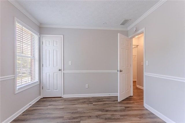 1797 Emerson Lake Cir, Snellville, GA 30078 - unfurnished bedroom featuring multiple windows, wood finished floors, a textured ceiling, a closet, and ornamental molding