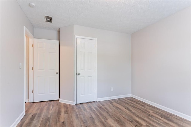 1797 Emerson Lake Cir, Snellville, GA 30078 - unfurnished bedroom featuring wood finished floors and a textured ceiling