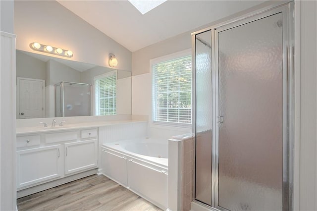 1797 Emerson Lake Cir, Snellville, GA 30078 - full bathroom with lofted ceiling, a garden tub, a stall shower, vanity, and wood finished floors