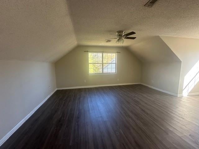 bonus room with a textured ceiling, lofted ceiling, and dark hardwood / wood-style floors