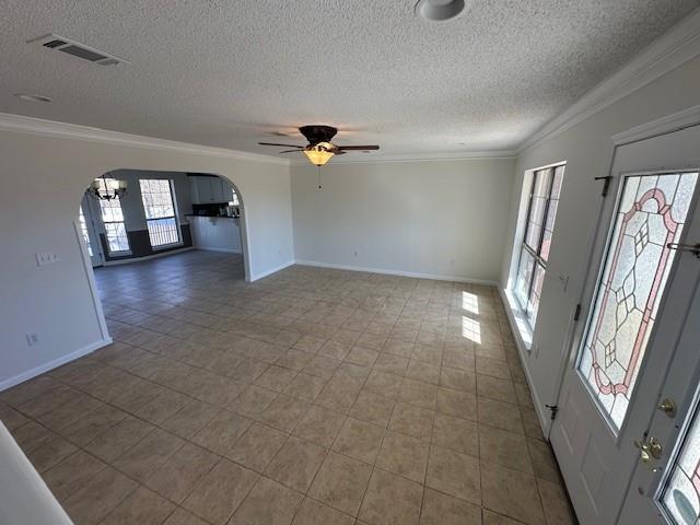 interior space with ceiling fan, crown molding, a textured ceiling, and tile patterned flooring