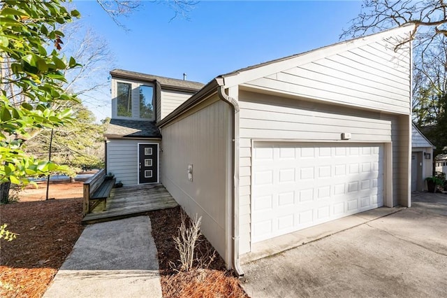 exterior space featuring an attached garage, driveway, and a deck