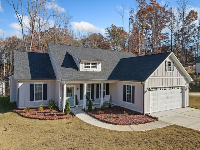 view of front of home featuring a front yard, a porch, and a garage