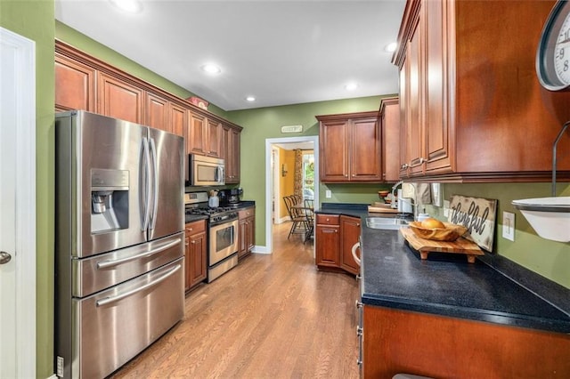 930 Brenau Point Dr, Gainesville, GA 30501 - kitchen with appliances with stainless steel finishes, dark countertops, light wood-style floors, a sink, and recessed lighting