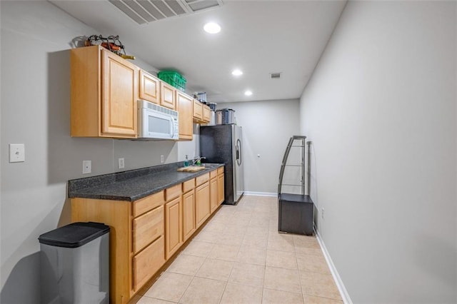 930 Brenau Point Dr, Gainesville, GA 30501 - kitchen featuring white microwave, stainless steel fridge, recessed lighting, light tile patterned floors, and dark countertops