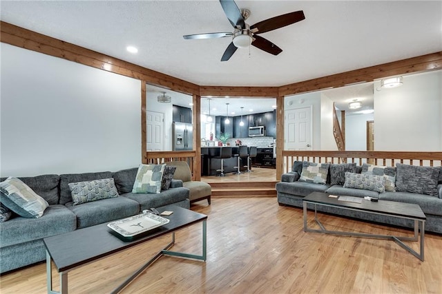 living room featuring ceiling fan and light hardwood / wood-style floors