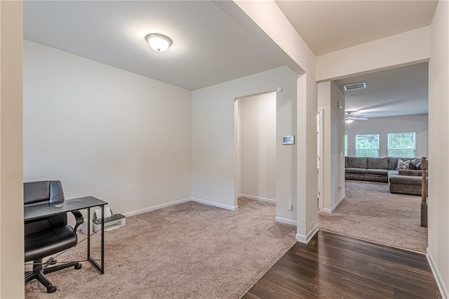 carpeted home office featuring ceiling fan