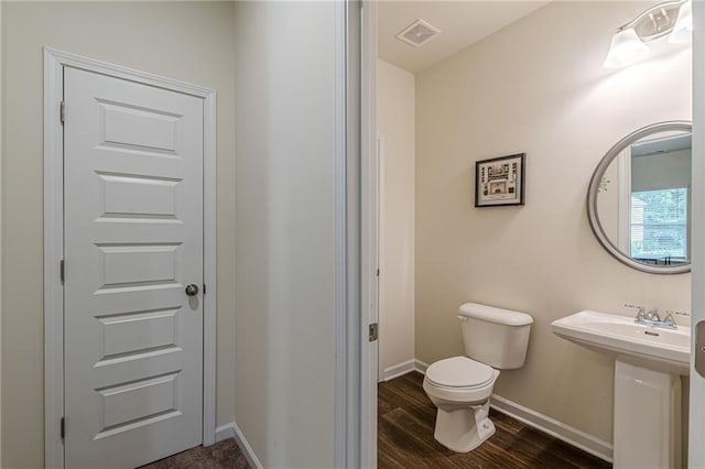 bathroom featuring toilet and wood-type flooring