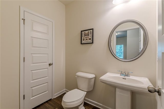 bathroom with toilet, wood-type flooring, and sink