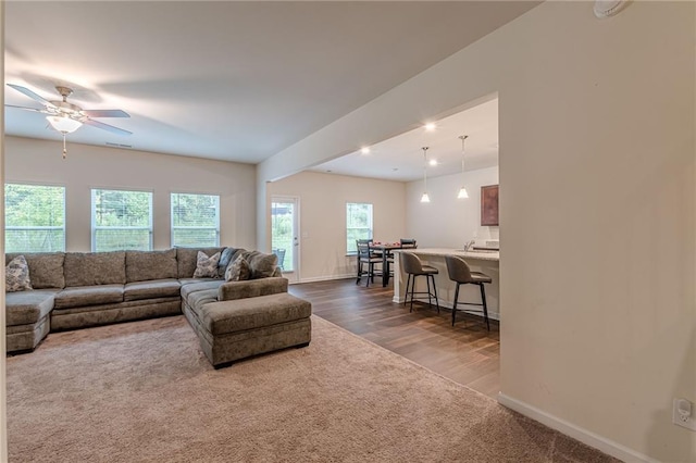 living room featuring dark hardwood / wood-style flooring and ceiling fan