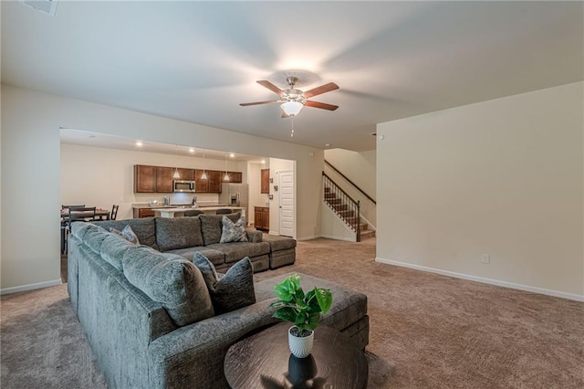 carpeted living room with ceiling fan