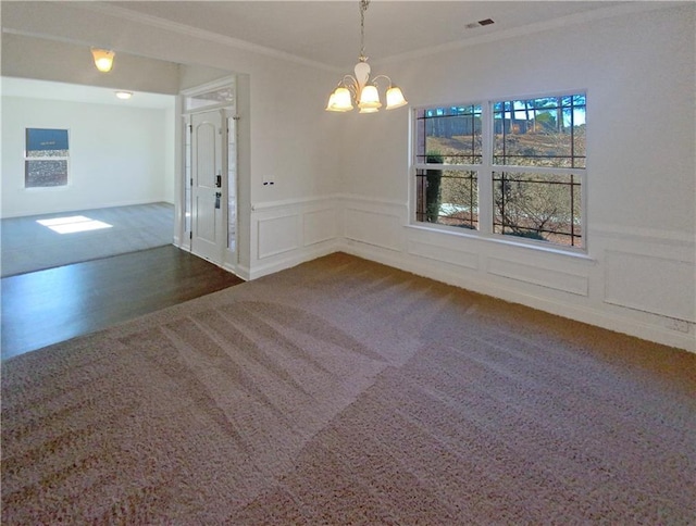 unfurnished dining area featuring dark colored carpet, ornamental molding, and a notable chandelier