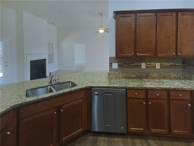 kitchen featuring tasteful backsplash, sink, stainless steel dishwasher, and light stone counters