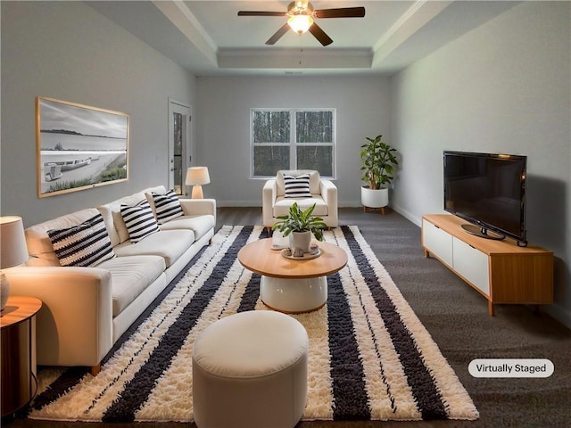 living room with a raised ceiling and ceiling fan