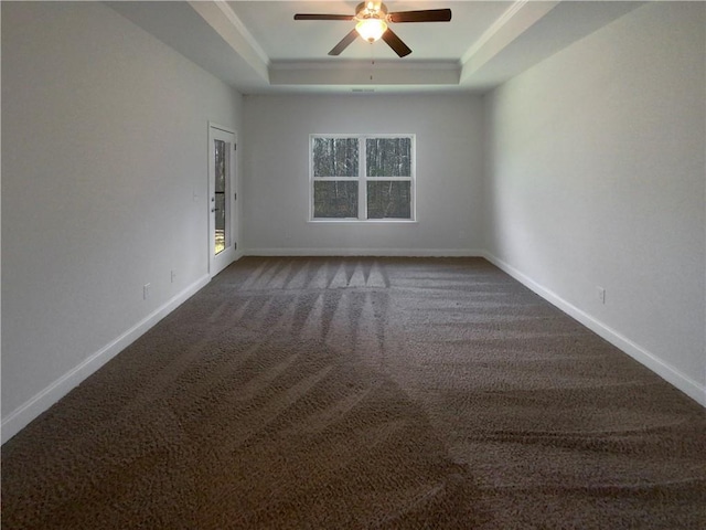 spare room featuring ceiling fan, a tray ceiling, and carpet